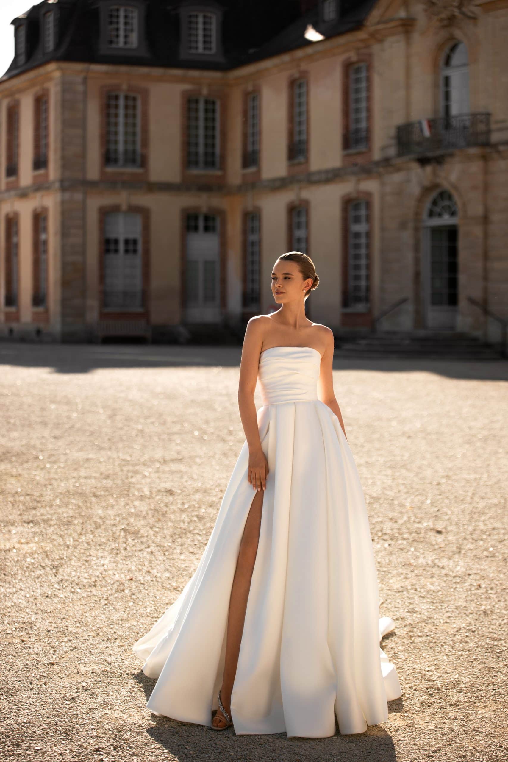 Bild von vorne: schlichtes und elegantes weißes Brautkleid mit Beinschlitz und trägerlos